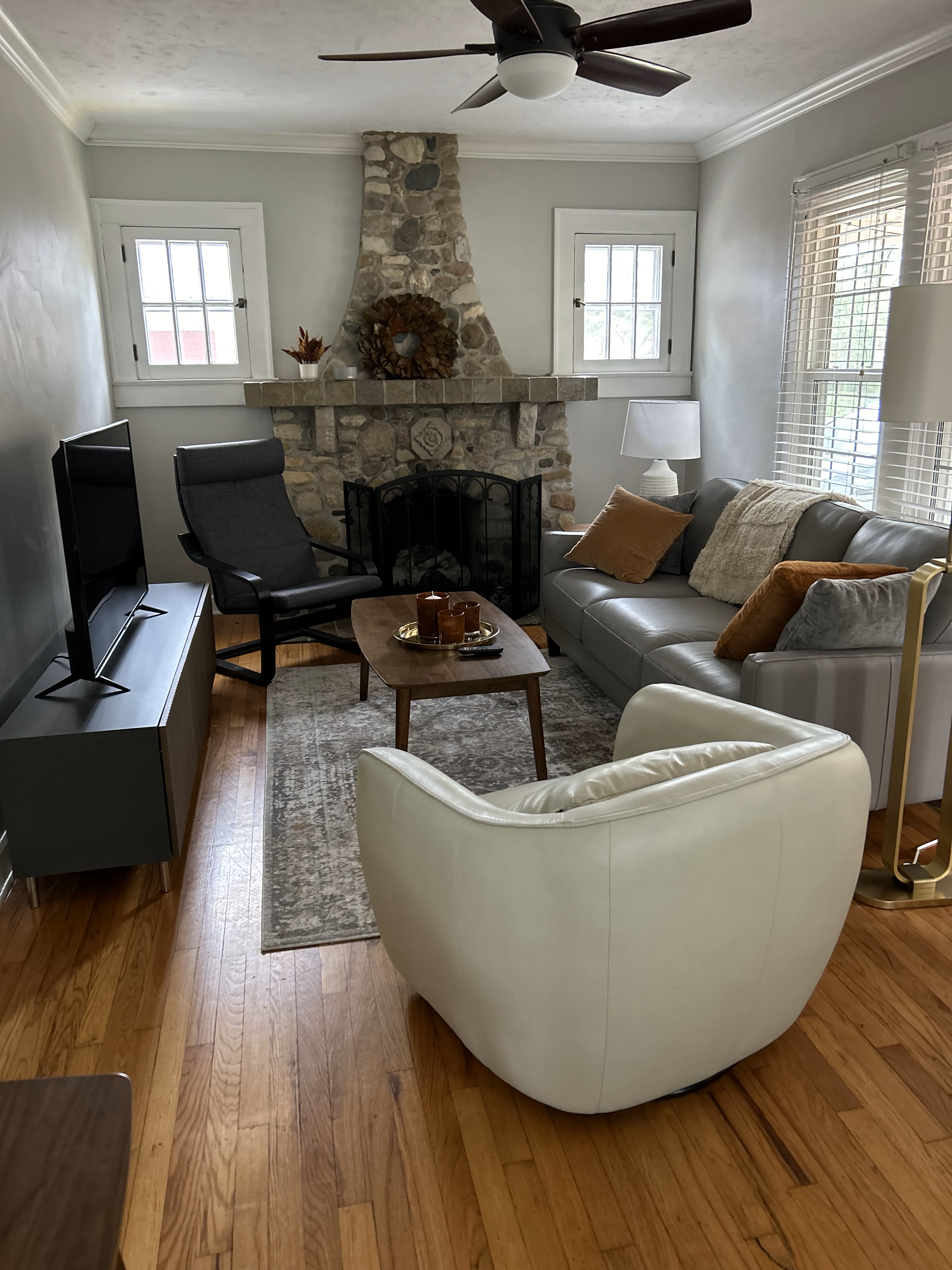 Cozy living room with a stone fireplace, modern furnishings, a smart TV, and warm lighting at Rosslyn Retreat.