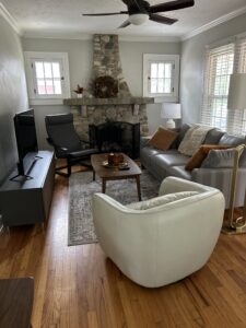 Cozy family room at Rosslyn Retreat with a stone fireplace, modern furniture, and natural light